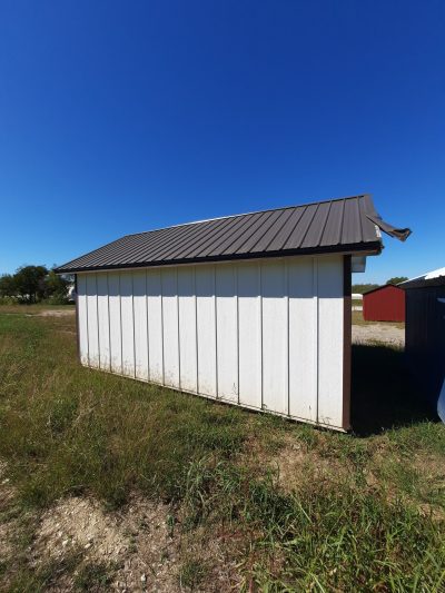 A 12x20 Chalet Shed for sale, located in the center of a field.