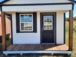 A white and black 12x20 Cabinette Shed with a porch, available for sale.