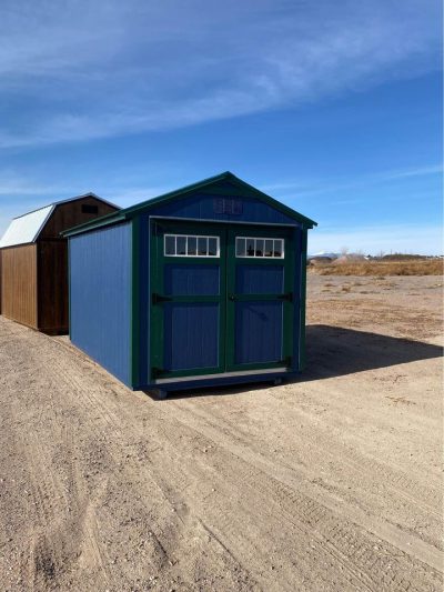 Two 8x14 Utility Sheds for sale near me in a dirt field.