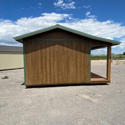 A 12x16 Cottage Shed for sale in a parking lot.