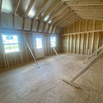 A cozy room with warm wood floors and walls, like the 16x24 Lofted Barn Shed.