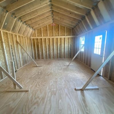 For sale 16x24 Lofted Barn Shed: The inside of a wooden shed with wood flooring, available for purchase.