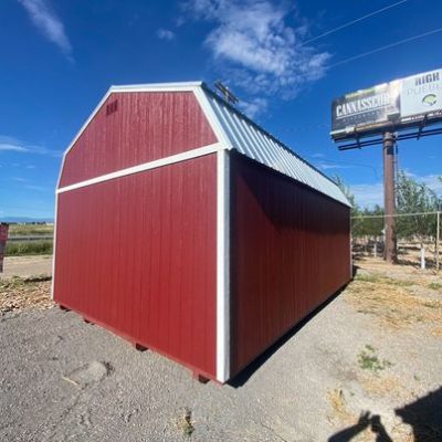 A red and white 16x24 Lofted Barn Shed available for sale in a parking lot.