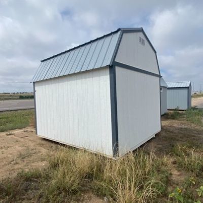 A 10x12 Lofted Barn Shed with a metal roof for sale, sitting in a field.