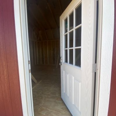 A 16x24 Lofted Barn Shed door with a white door on sale near me.