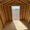 A tiny house with an open door, available for sale nearby at 8x10 Utility Shed store.