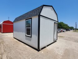 A 12x20 Lofted Barn Shed sitting in a parking lot, available for sale.