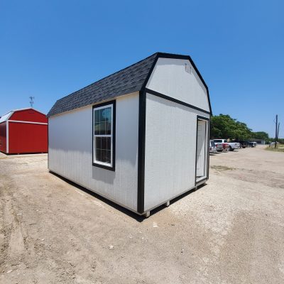 A 12x20 Lofted Barn Shed sitting in a parking lot, available for sale.