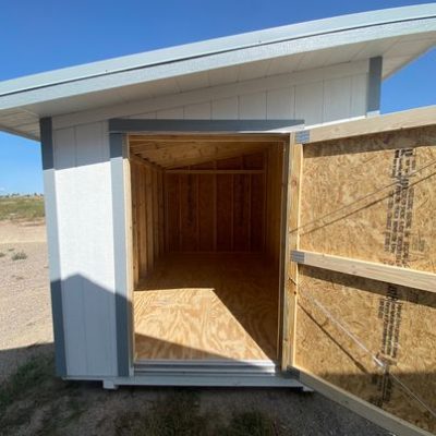 A 8x12 Studio Shed with the door open, available for sale.
