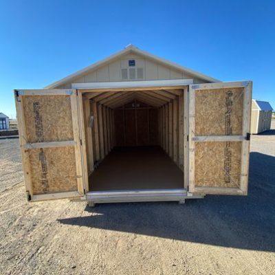 For sale 8x16 Basic Shed: A storage shed with a door open in a dirt lot.