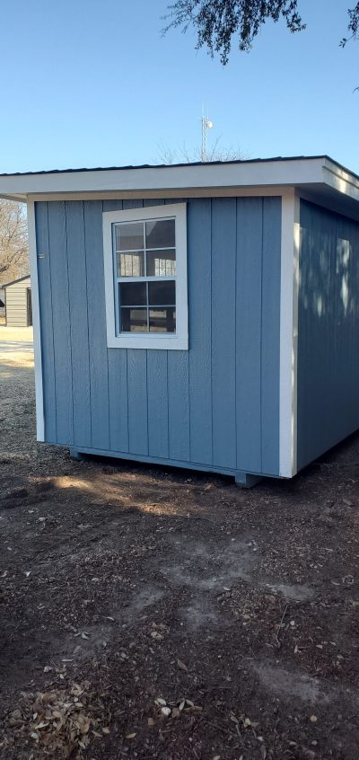 A small 8x12 Studio Shed for sale in a field.
