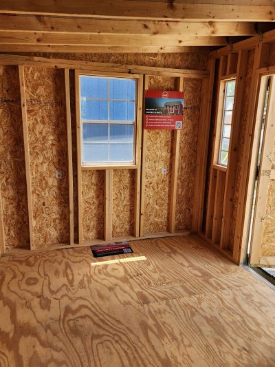 A room with wood flooring and a window, perfect for transforming into an 8x12 Studio Shed.