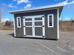 A 10x14 Studio Shed for sale near me in a parking lot.
