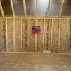 A room with plywood walls and wood flooring, perfect for those searching for "12x24 Lofted Barns on sale" near me.