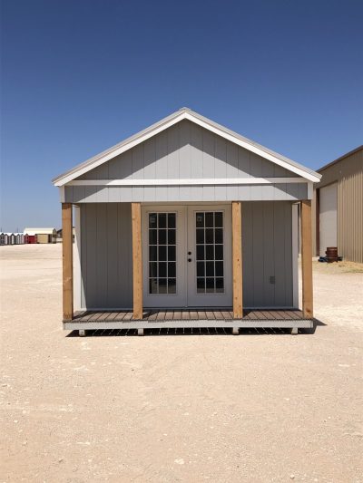 A 14x20 Diamond Cabinette Shed with a porch in the middle of a desert, for sale.