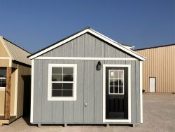 Two 14x20 Diamond Chalet Sheds on sale in a parking lot.
