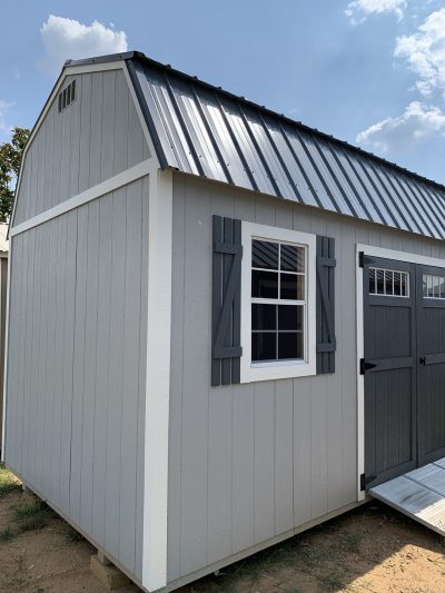 A gray 10x20 Lofted Barn with a metal roof and a door available for sheds sale near me.