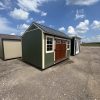 Two 10x14 Garden Sheds for sale in a parking lot.