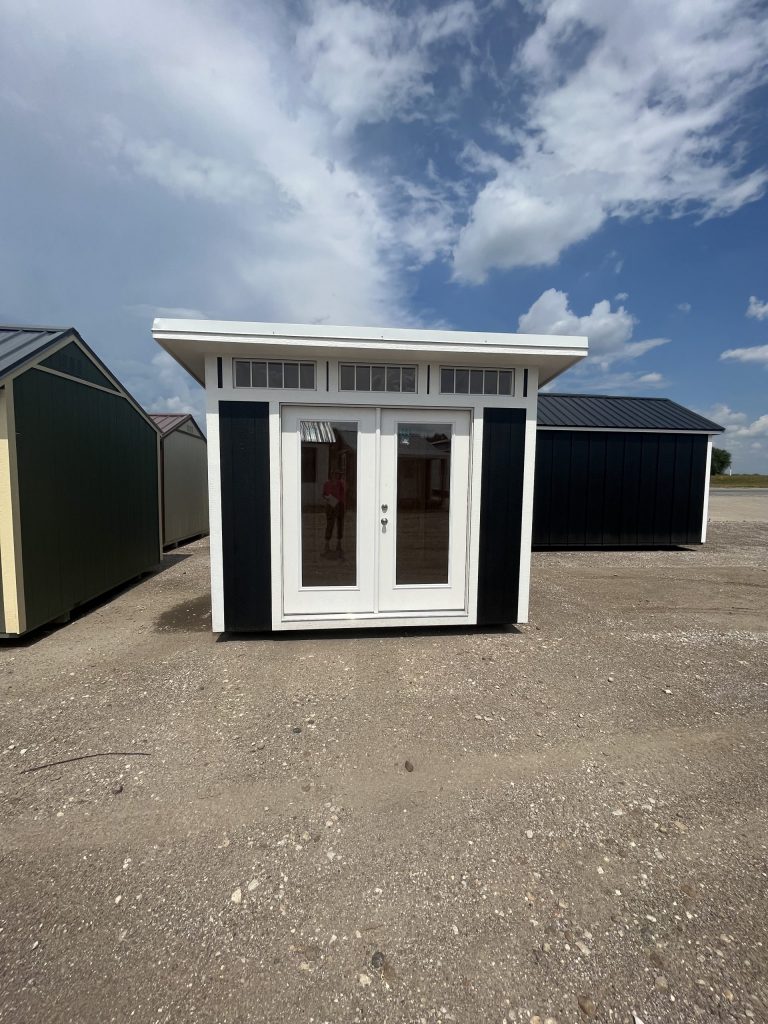  -  - For sale: Two black and white 8x10 Studio Sheds in a parking lot.