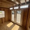 The inside of an 8x10 Studio Shed with doors and windows, available at sheds on sale.