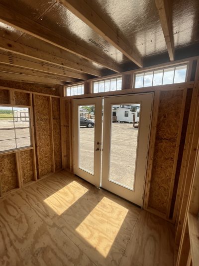 The inside of an 8x10 Studio Shed with doors and windows, available at sheds on sale.