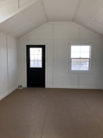 An empty 14x20 Diamond Chalet Shed with white walls and a door, available for sale in a shed store near me.