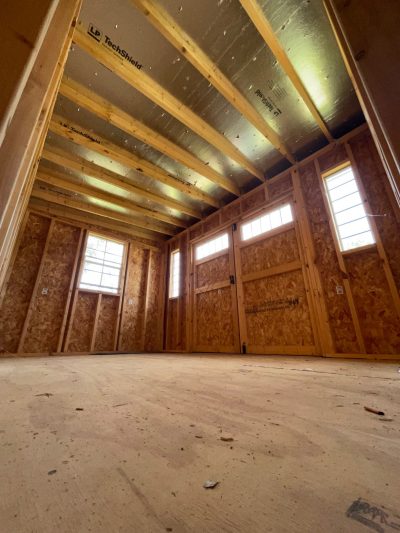 The inside of an unfinished room with wood flooring is reminiscent of an 8x12 Studio Shed or a shed store near me.