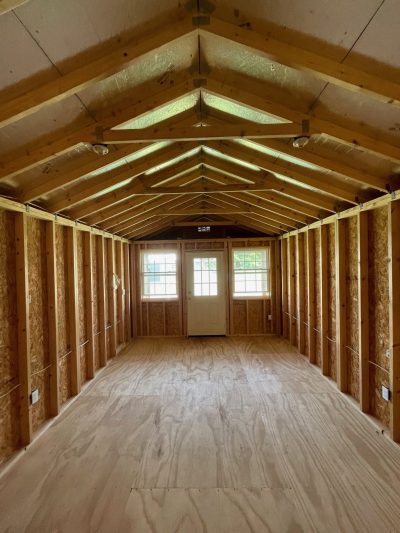 The inside of a 12x24 Cabinette Shed for sale, with wood flooring.