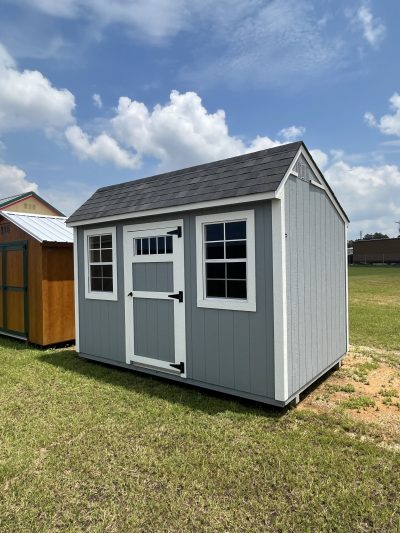 Two 8x12 Garden Sheds for sale in a field next to each other.