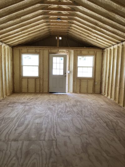 An empty 16x30 Cabinette Shed with plywood walls that features wood flooring.