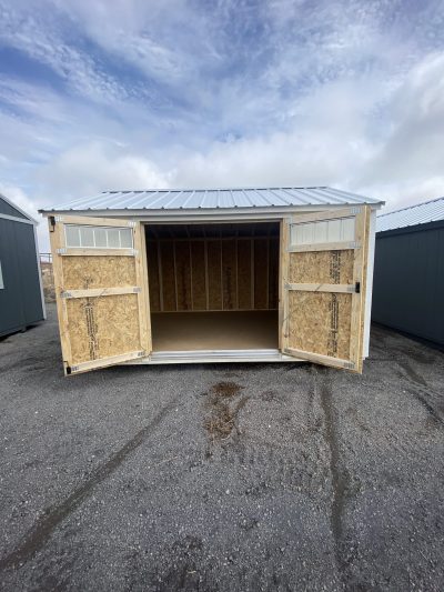 A 10x14 Utility Shed for sale with doors open in a parking lot.