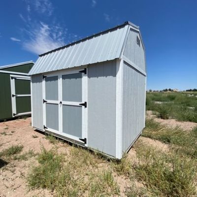 An 8x12 Lofted Barn Shed for sale in the middle of a field.