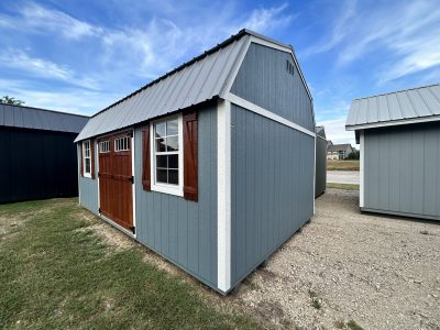 For sale: A 12x20 Lofted Barn with a blue roof and a wooden door. Perfect for those seeking sheds on sale.