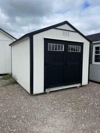 Two 10x12 Utility Sheds in a gravel lot, perfect for those searching for sheds on sale.