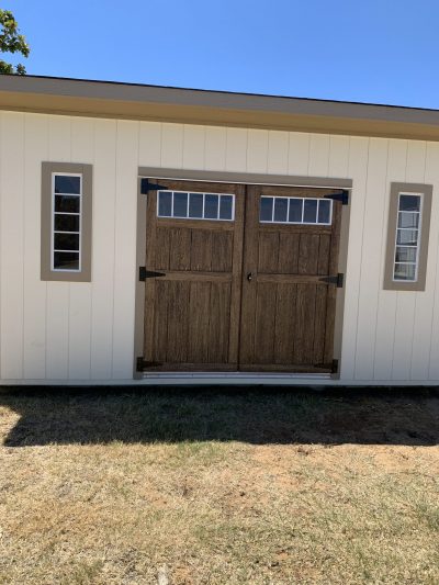 An 8x16 Studio Shed with a wooden door, available for sale at a nearby shed store.