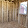 A room with wooden walls and a window, perfect as an 8x16 Studio Shed or storage space.
