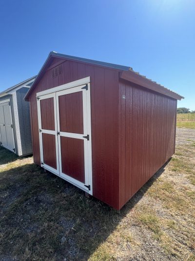 Two 10x12 Basic Sheds, one red and one white, located in a field.