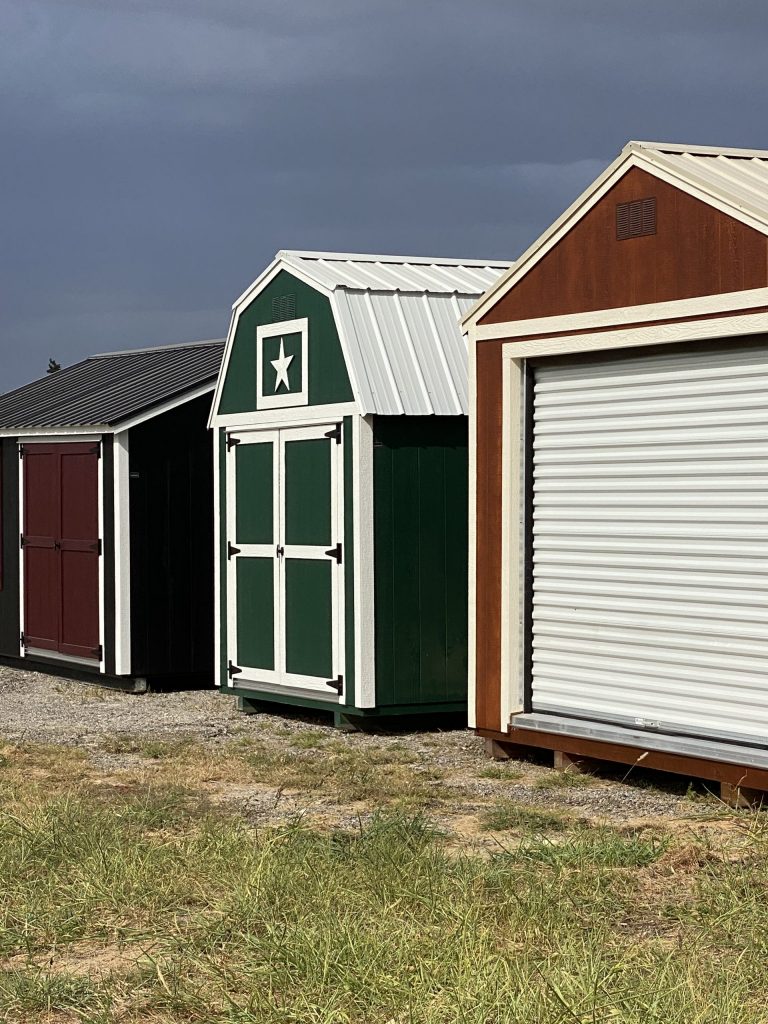 A row of 8x12 Lofted Barn Sheds with a garage door available for sale.