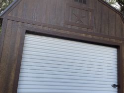 A 12x24 Lofted Barn with a garage door on it available at sheds on sale.