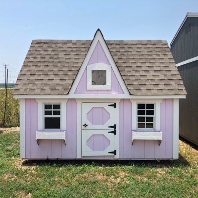 An 8x12 Victorian Playhouse for sale in a grassy area.
