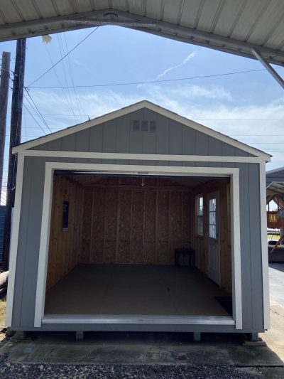 A 12x16 Garage Shed with a door open in front of it, available for sale.