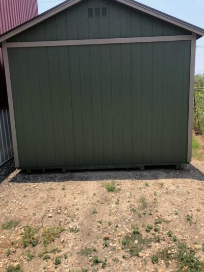 A 12x20 Cabinette Shed for sale sitting in a field.