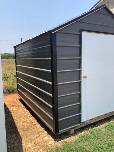 Description: An 8x10 metal shed with a door on it available for sale.