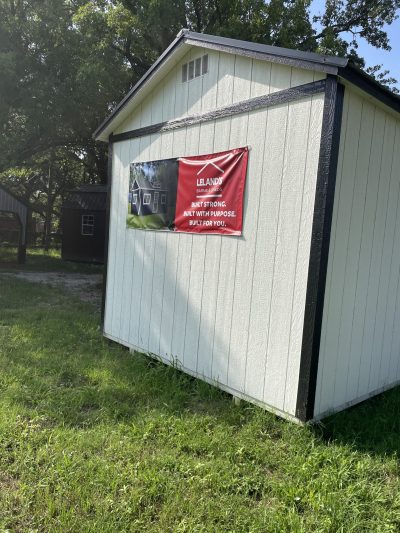 A 10x24 Cabinette Shed for sale with a red banner on it.